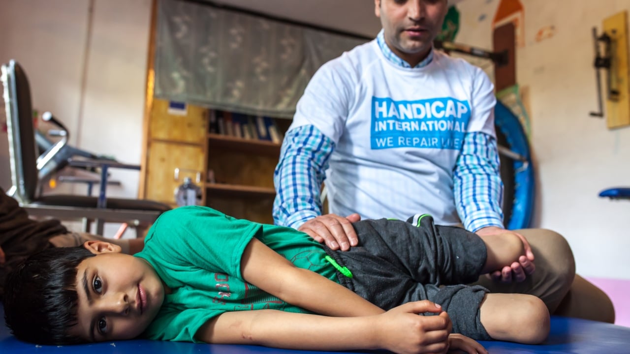 Fayaz durant une séance de réadaptation avec Muddasir Ashraf, physiothérapeute et Disability Manager pour Handicap International